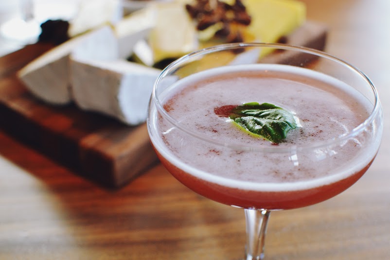 Grand Marnier, Chambord, fresh pressed strawberry, fresh basil, spice syrup, twist of black pepper served in a martini glass 